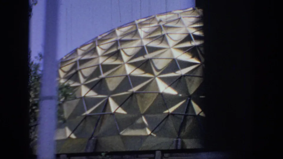 1967 Oklahoma 8mm frame showing a triangular-patterned dome facade seen through dark roadside or vehicle framing.