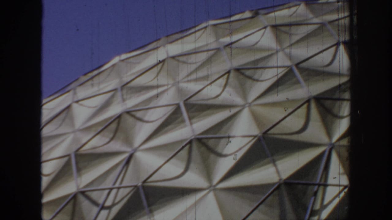 1967 home-movie frame of a cream geodesic dome in Oklahoma, tightly framed on its patterned exterior.