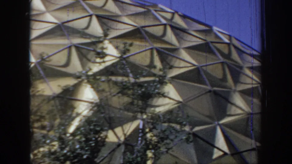 Curving faceted dome surface in Oklahoma, 1967, filmed from outside with branches silhouetted against the structure.