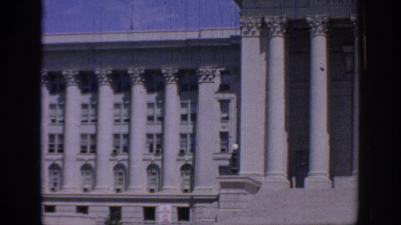 Oklahoma State Capitol exterior in a 1967 home-movie frame, showing columns, window rows, stonework, and film gate borders.