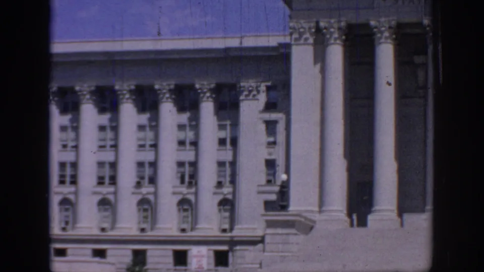 Oklahoma State Capitol exterior in a 1967 home-movie frame, showing columns, window rows, stonework, and film gate borders.