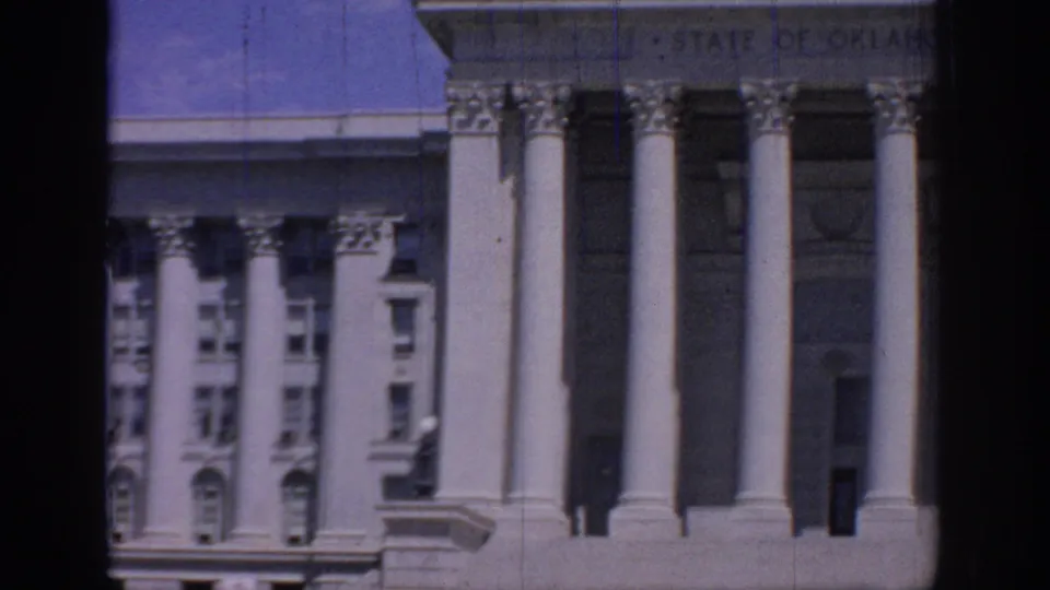 1967 Oklahoma State Capitol entrance area, with large columns, stone facade, windows, and a partly visible state inscription.