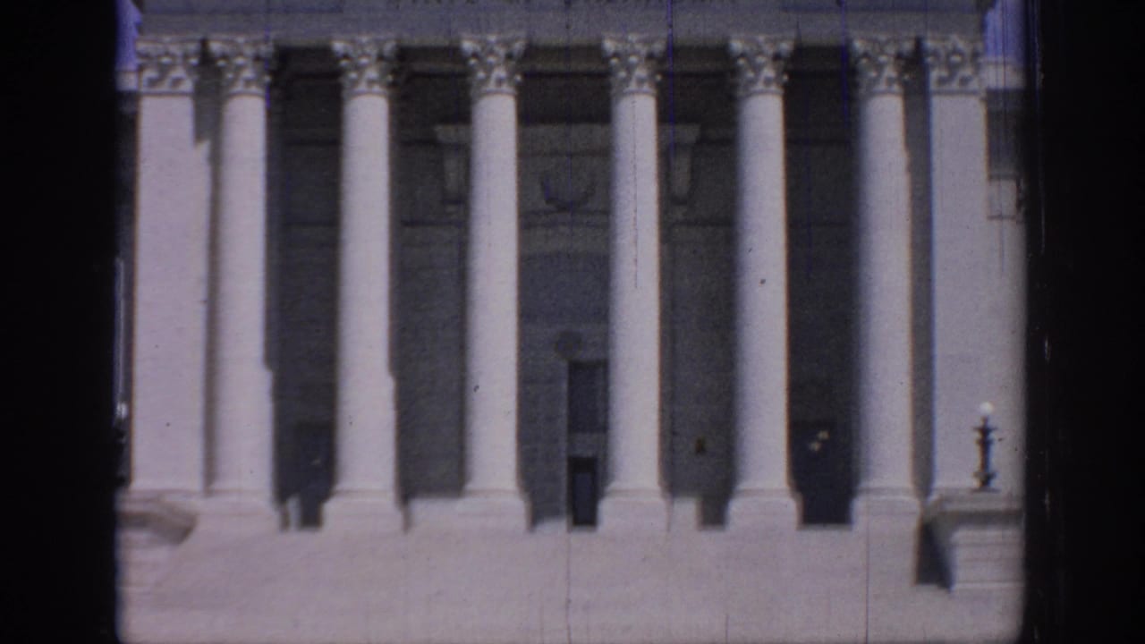 Columned capitol entrance with deep shadows and part of the pediment visible.