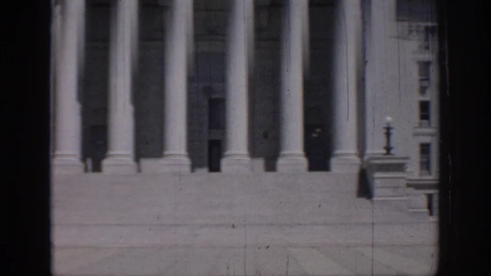 1967 8mm frame showing the lower Oklahoma State Capitol facade, broad steps, columns, and part of the adjoining windowed wall.