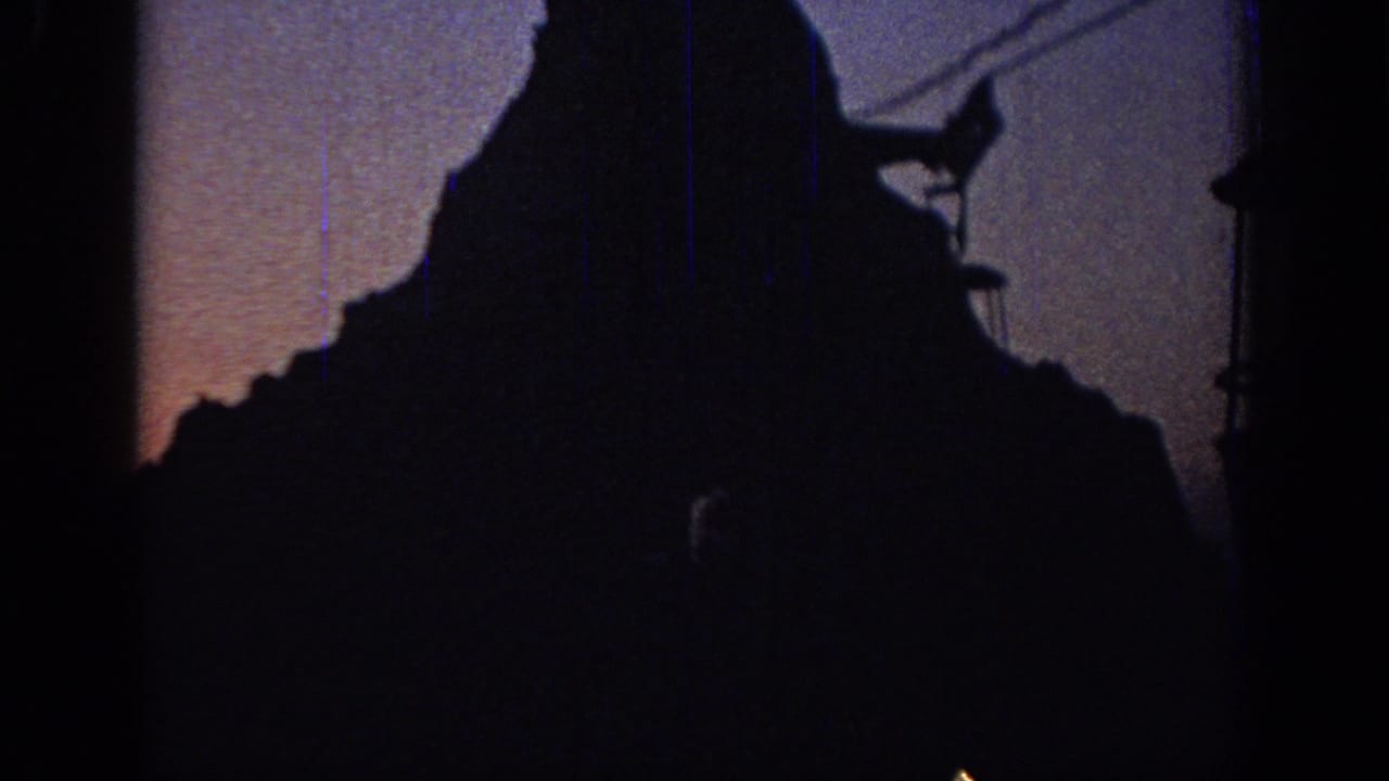 Dark cable car system and peak form nearly fill the frame at dusk.