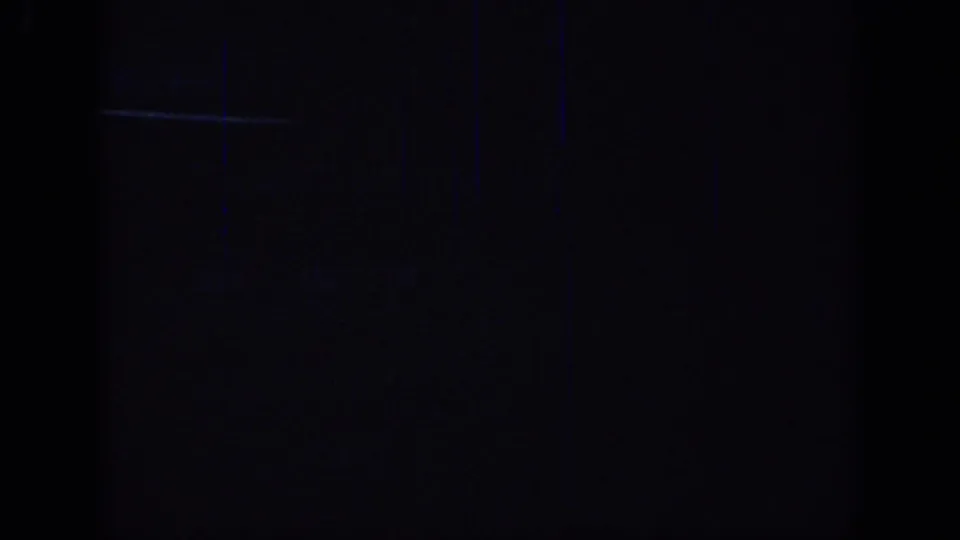 Final 1967 Oklahoma 8mm frame fading into darkness with only faint cable car forms and a small light visible.