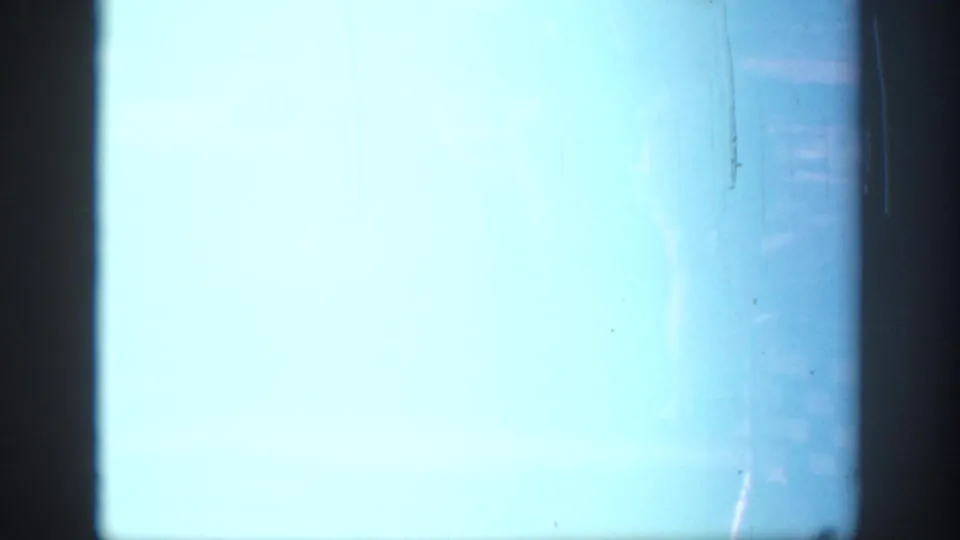A mostly overexposed 8mm frame with a pale blue field and only a small visible portion of the Oklahoma park picnic at the upper right.