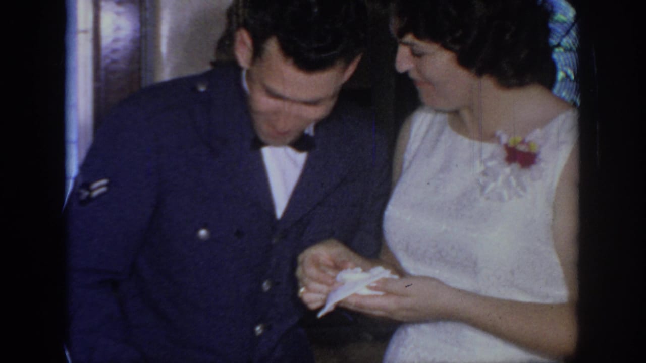 Serviceman and woman look down at a small paper indoors.