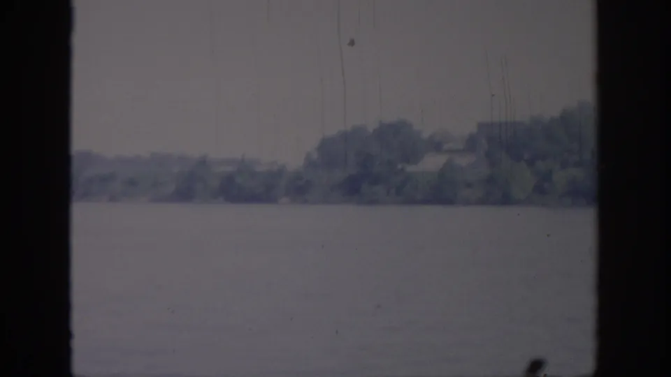1967 Oklahoma 8mm frame with open water in front of a soft distant treeline and indistinct shore details.