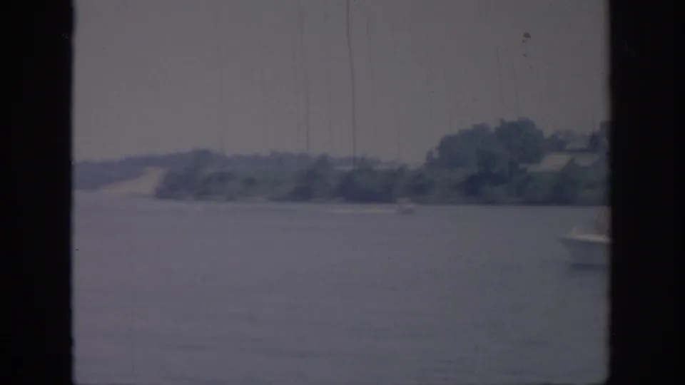 A small motorboat begins to enter the right edge of a 1967 Oklahoma water scene, framed by dark vertical bars.