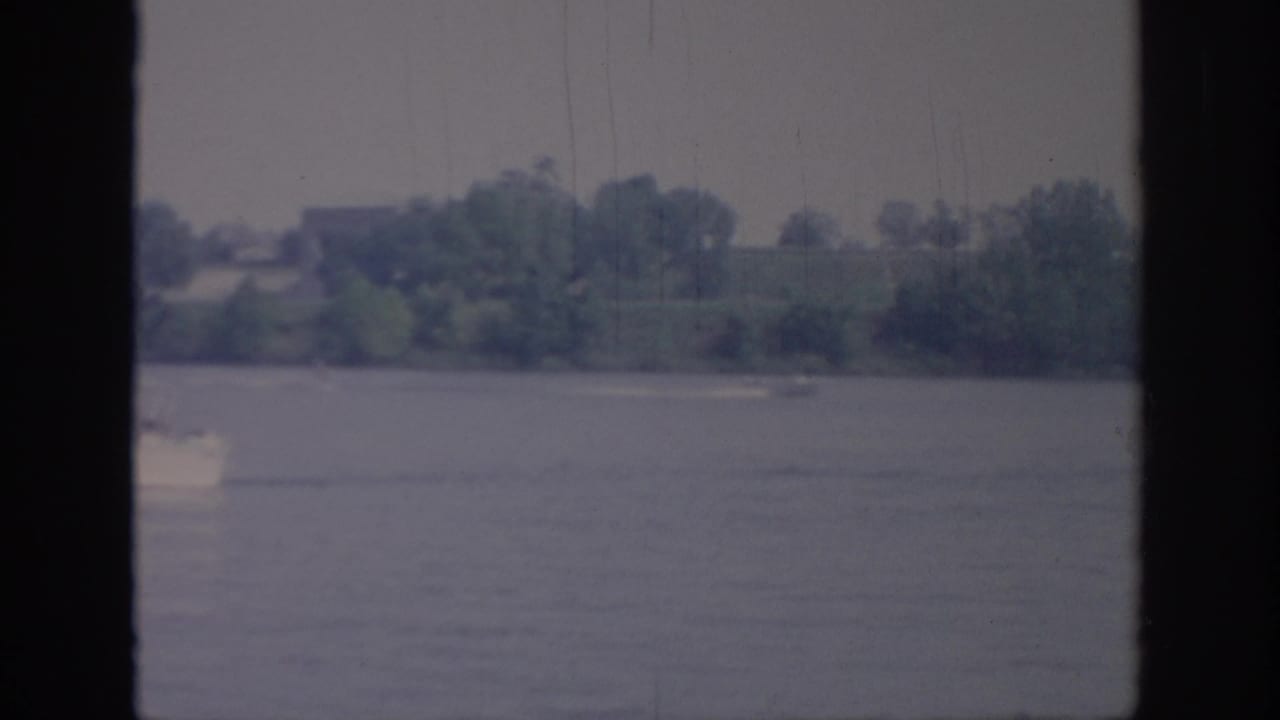 The white boat is partly cropped at the left edge as it moves across the lake in the 1967 Oklahoma home movie.