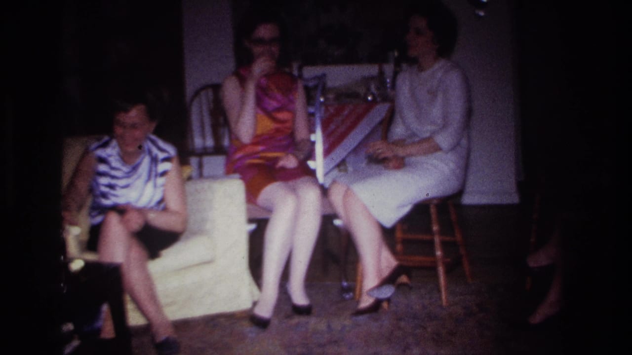 1967 Rockaway Beach interior frame with three women seated close together, one in a striped top and another in a bright dress holding a drink.