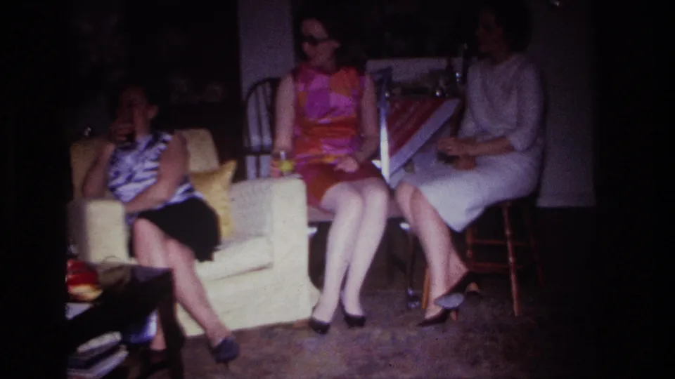 Rockaway Beach 1967 8mm frame showing three adult women in a private living room, seated with drinks during a casual gathering.