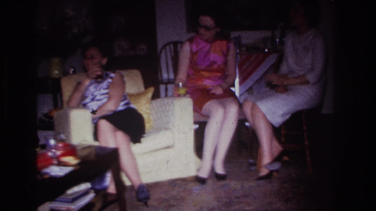 Women seated together in a living room, one holding a drink.
