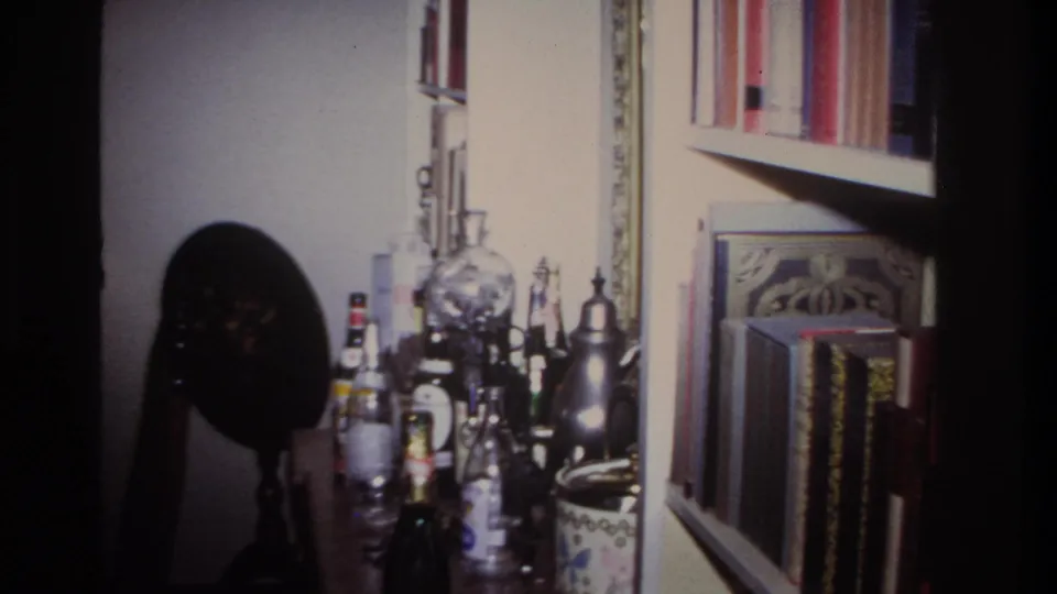 Final frame shows liquor bottles, a decorative globe, bookshelves, and framed decor in the Rockaway Beach home interior.