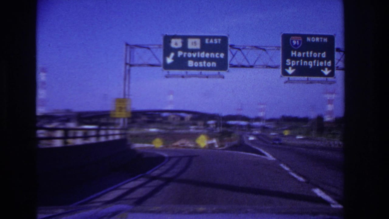1967 8mm driving view on a multi-lane highway with overhead signs directing toward Providence, Boston, Hartford, and Springfield.