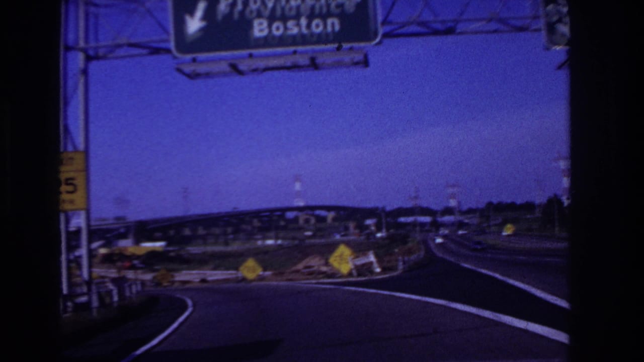 Highway ramp area with a large overhead sign for Providence and Boston.