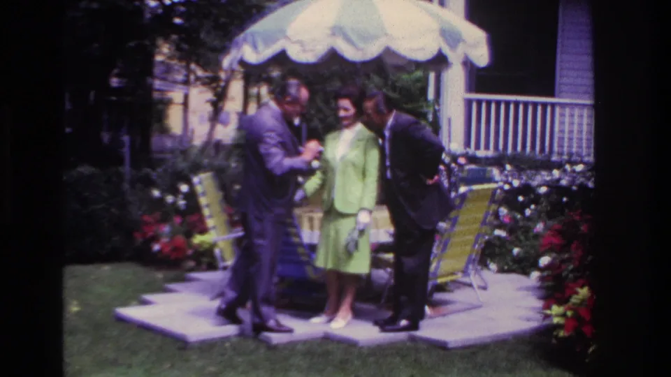 The final frame shows the Rockaway Beach patio group leaning together under the umbrella, with garden flowers and a porch in the background.