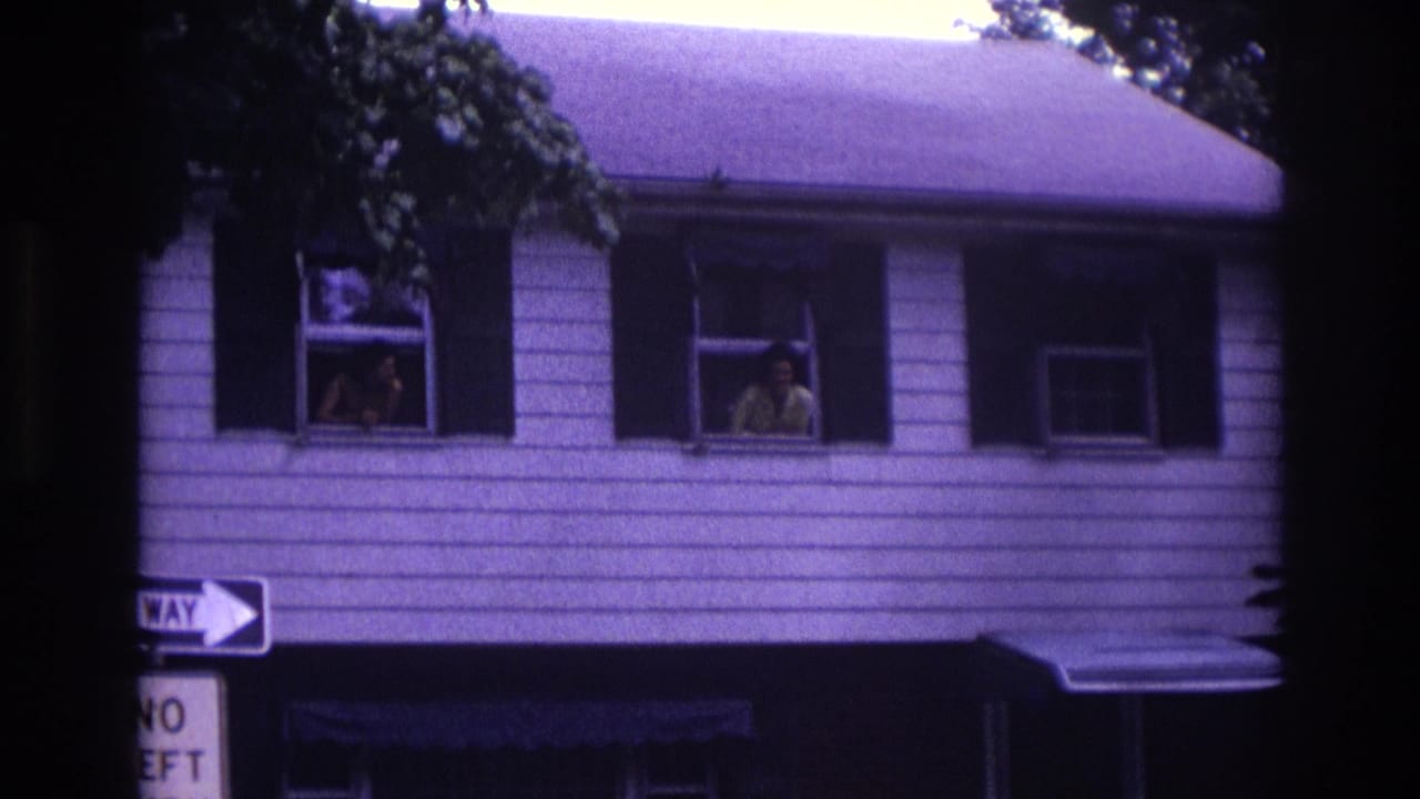 Rockaway Beach street view with adults at separate upstairs windows, a window air conditioner, and ONE WAY signage below.