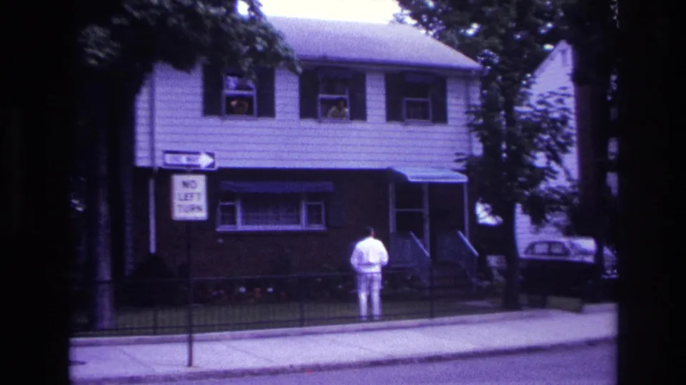 1967 Rockaway Beach frame with a white-clad man facing a residential house, street signs at left, and window figures above.