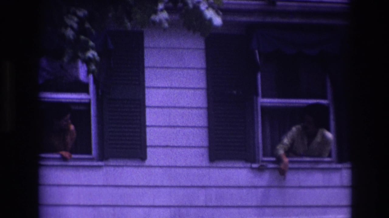 1967 Rockaway Beach frame with one adult woman leaning from a right-side second-story window and another person visible at a left window.