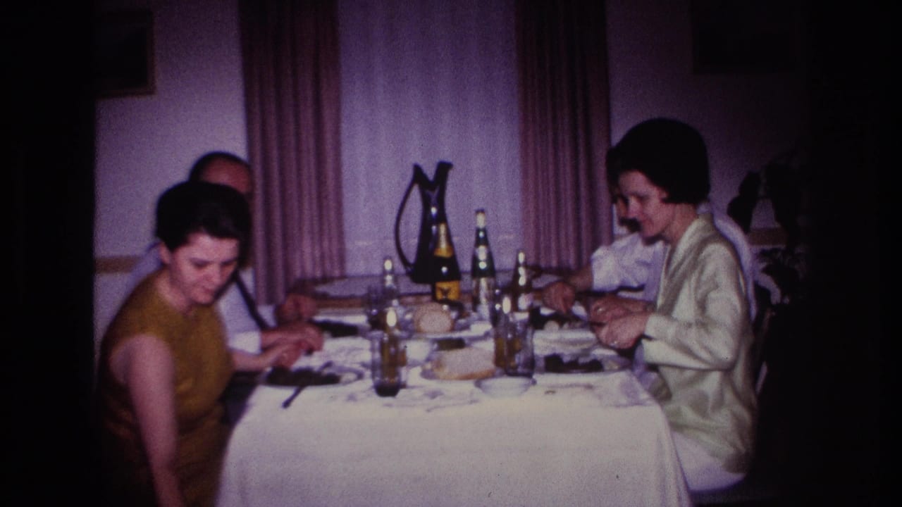1967 Rockaway Beach domestic dinner scene with adults seated at a table, glassware and bottles arranged in the center, and curtains behind them.