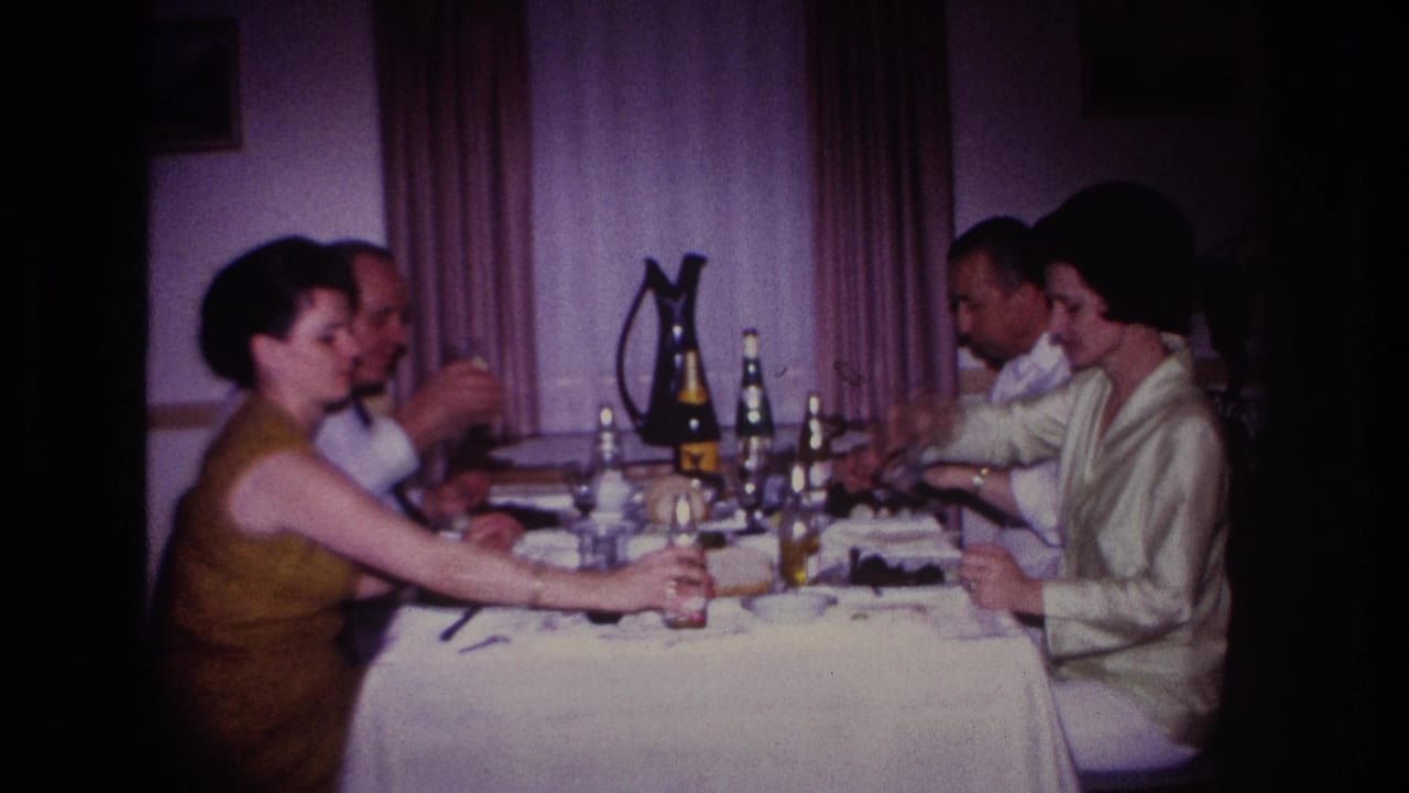 Four adults in a 1967 Rockaway Beach interior share dinner and drinks at a formally set table.