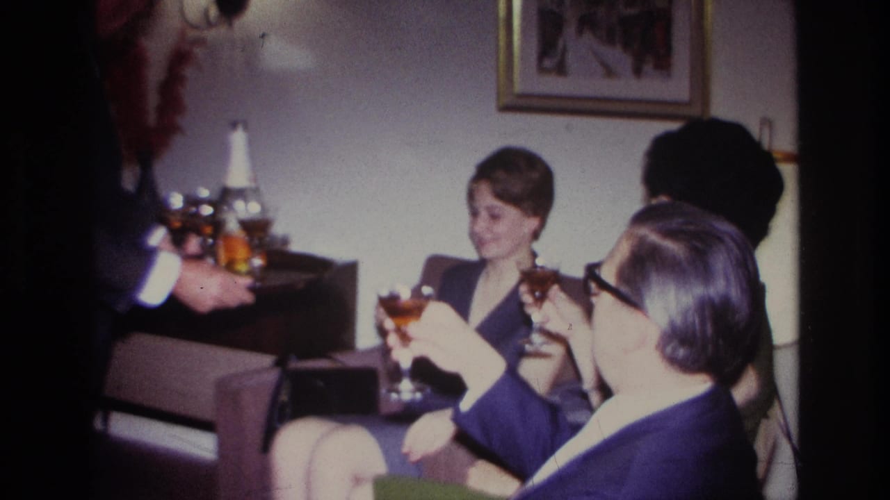 1967 Rockaway Beach living-room gathering with adults holding cocktail glasses as a suited man serves from a tray.