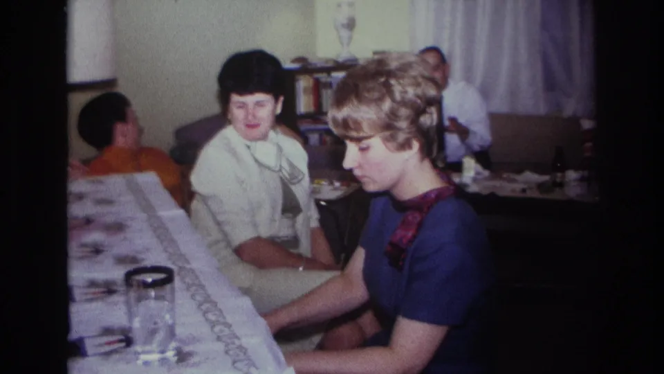 Rockaway Beach 1967 home-movie frame with a woman at the piano and another woman looking toward the camera.