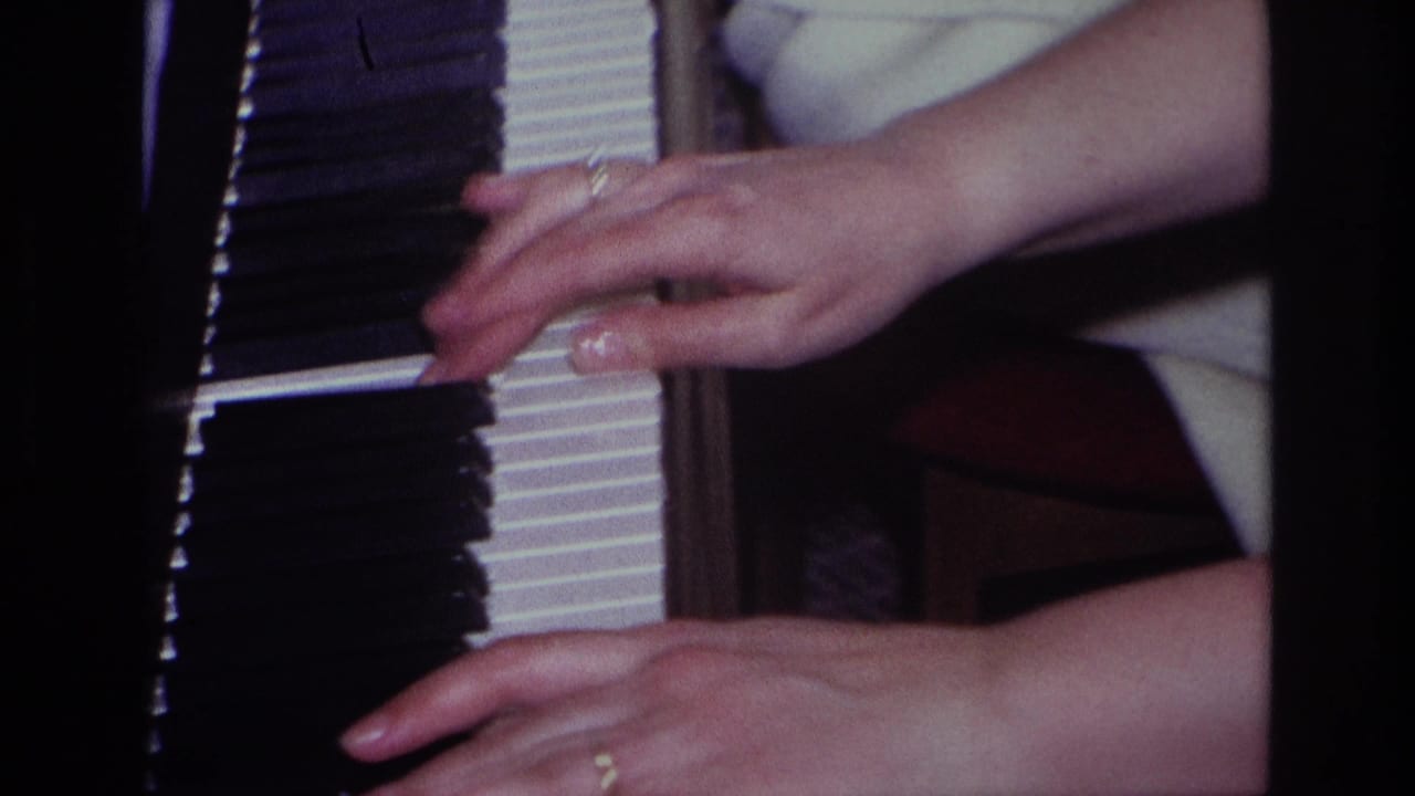 Close view of hands moving over black and white piano keys.