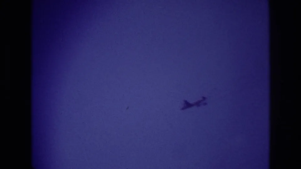 A small airplane is framed lower against the blue-purple sky, consistent with handheld 1967 Rockaway Beach home-movie footage.