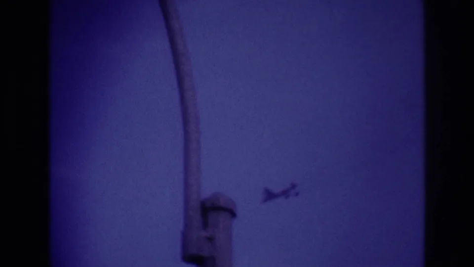 The airplane appears at right in the 1967 Rockaway Beach sky shot, while a dark vertical obstruction enters the handheld frame.