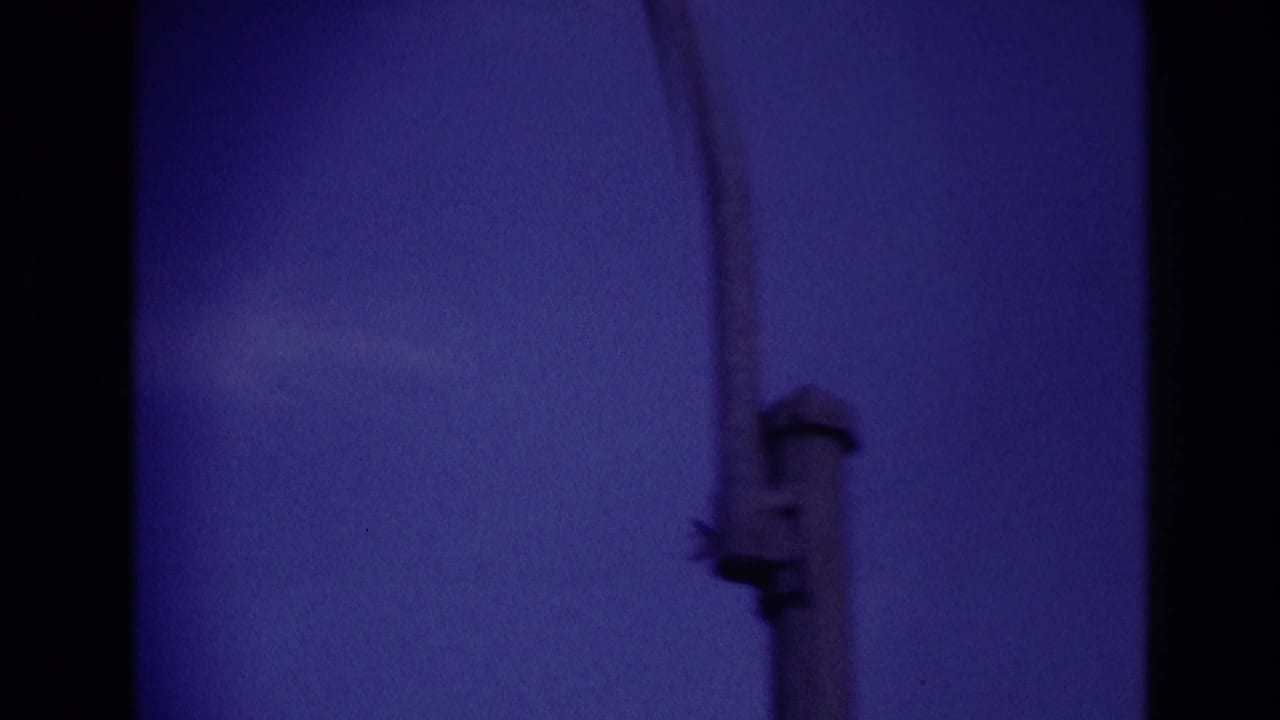 A silhouetted airplane appears in a purple-blue sky in 1967 Rockaway Beach home-movie footage, with dark frame edges visible.