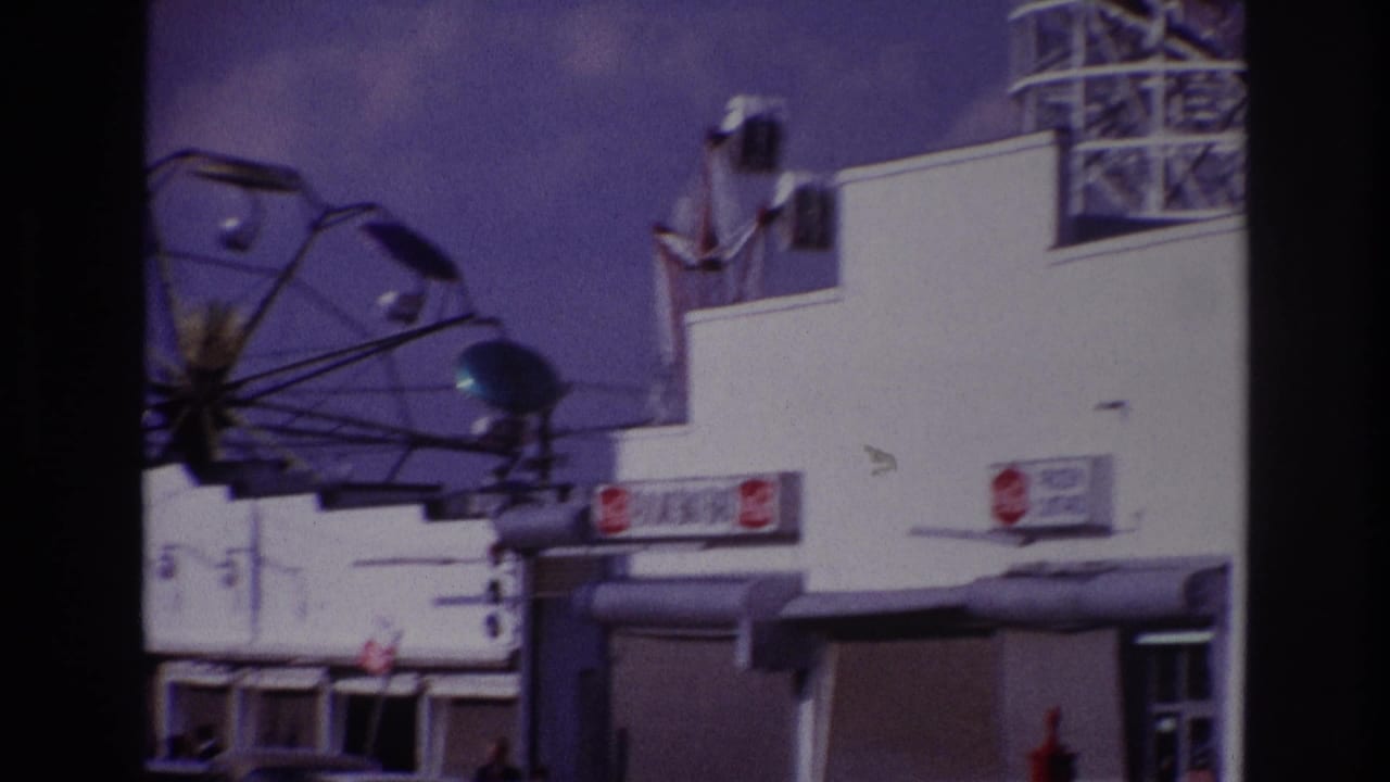 Rockaway Beach amusement frontage with the Ferris wheel, snack bar signs, and heavy dark frame edges from the film scan.
