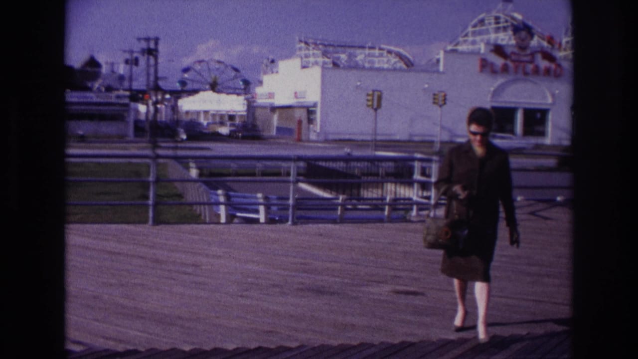Woman carrying a handbag walks closer on the boardwalk near Playland.