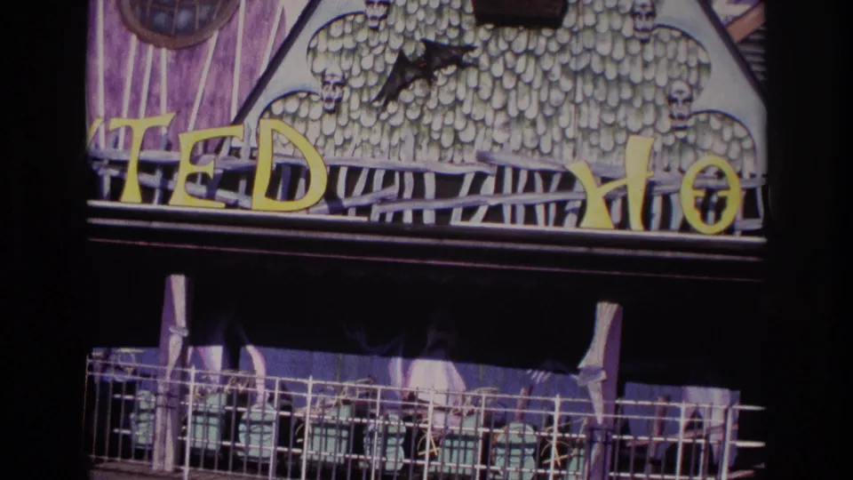 1967 8mm frame from Rockaway Beach showing the TEDDY HOUSE facade cropped above a metal railing and shaded lower section.