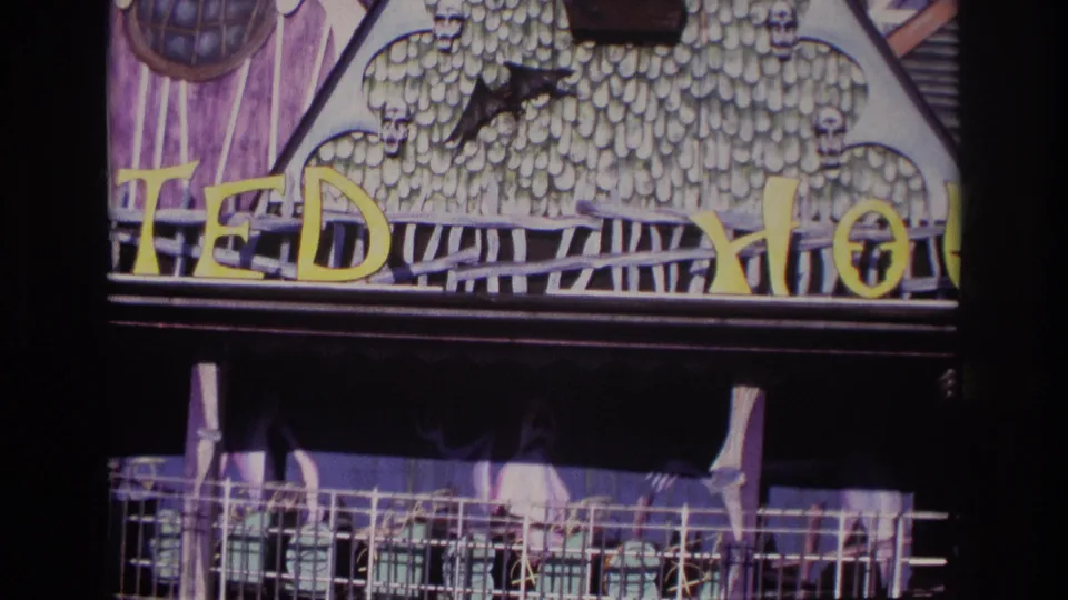 Rockaway Beach haunted attraction facade in 1967, with textured scenic panels, skull decorations, a bat silhouette, partial yellow lettering, and railings.