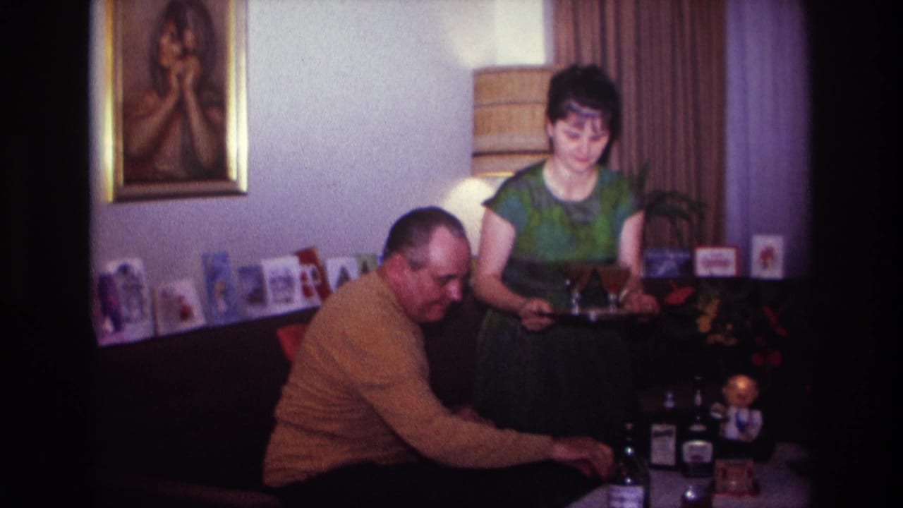 1967 Rockaway Beach living-room scene with a man reaching toward bottles while a woman holds a tray of drinks.
