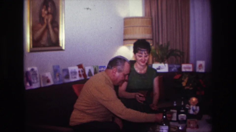 The closing 1967 Rockaway Beach frame shows the woman smiling as the man reaches across a table with bottles and glasses.
