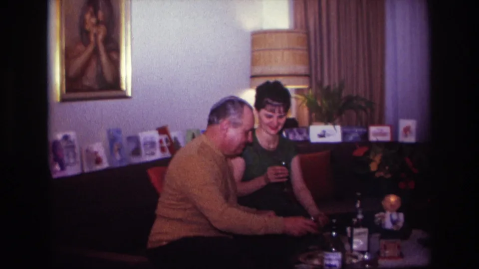 The final frame shows the man reaching toward the drink table as the woman smiles beside him in the 1967 Rockaway Beach home interior.