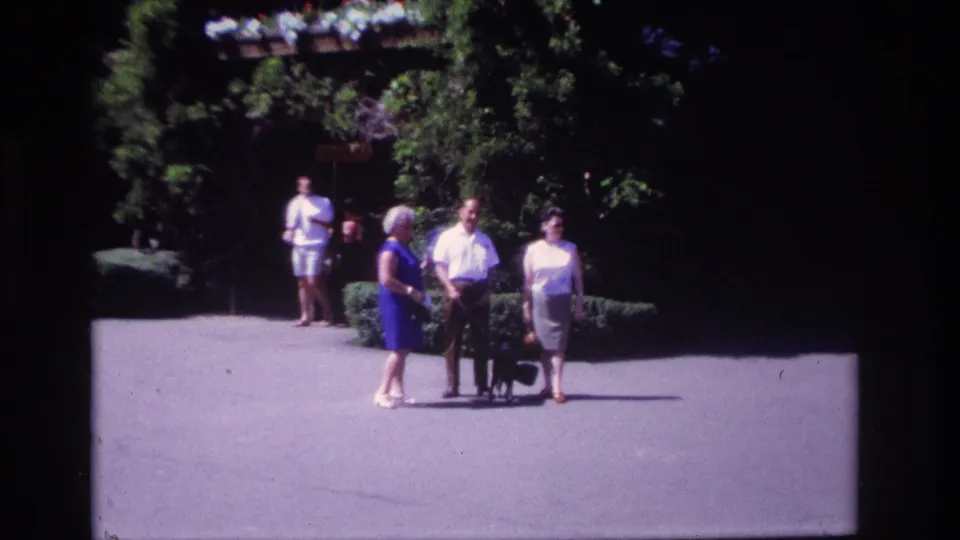 The group moves from the lawn to a paved path in Ocean City, with trees and other park visitors behind them.