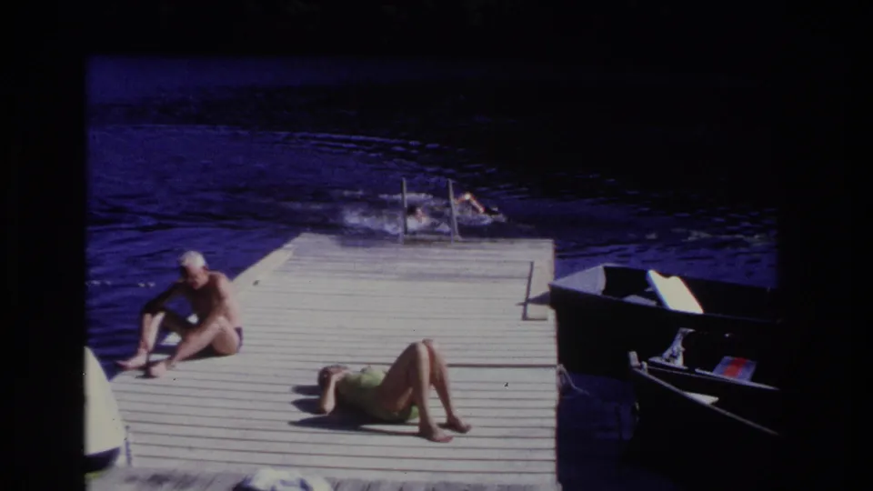 1968 dock scene in Ocean City with a woman sunbathing, a man seated nearby, and swimmers at the ladder.