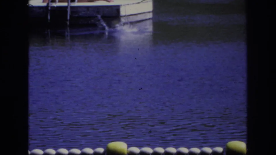 Final home-movie frame from Ocean City, New Jersey, 1968, showing a splash near the dock and buoy floats in the foreground.