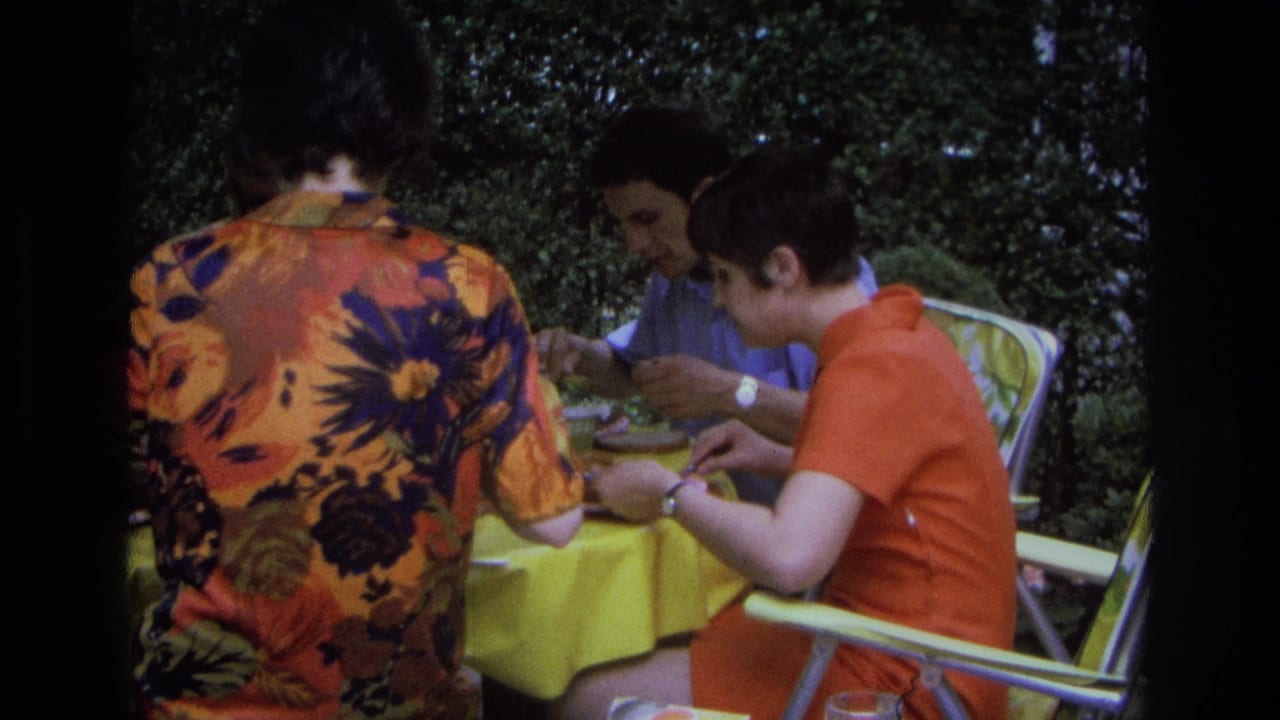 In Ocean City, New Jersey, 1968, three adults sit at a yellow-covered outdoor table eating from plates.