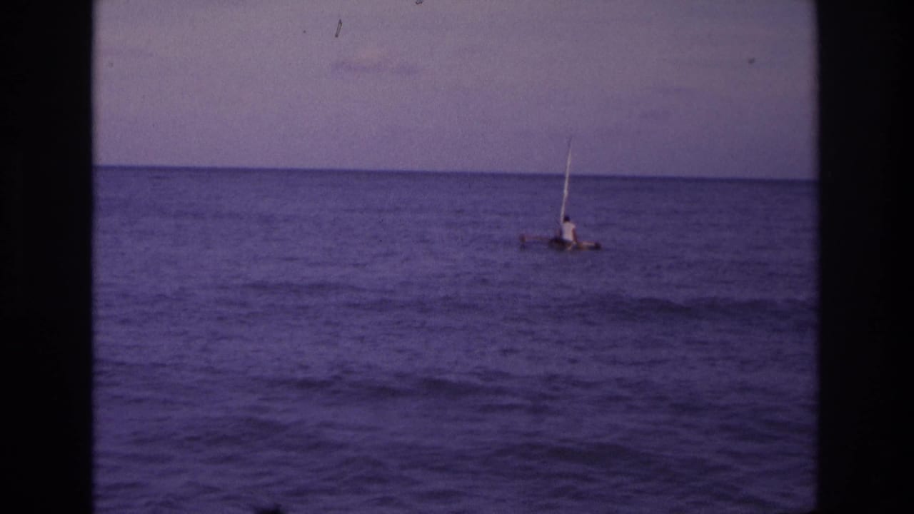 Distant 1968 Ocean City coastal view of a person on a small sail raft against a flat ocean horizon.