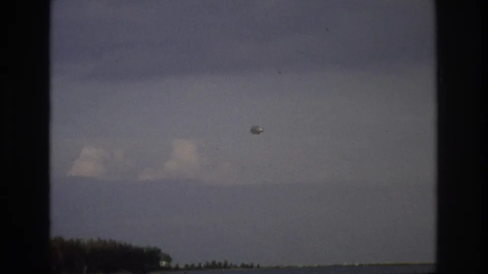 Ocean City coastal view from 1968 with a small pale object suspended over water and distant trees.