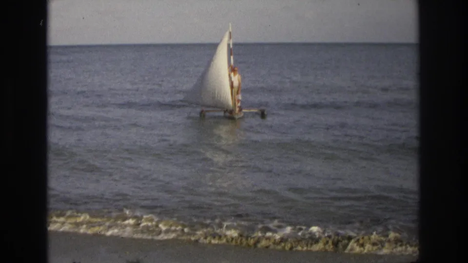 Ocean City, New Jersey 1968 home-movie frame showing a small sailboat close to shore with a person visible against calm water.