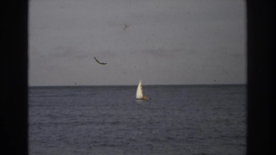 A distant sailboat and passing bird are visible over the ocean near Ocean City in 1968 8mm home-movie footage.