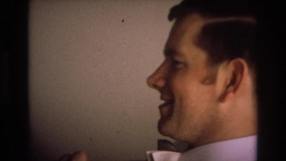A close 8mm frame shows a man laughing in profile in a private indoor setting associated with Ocean City, New Jersey, 1968.