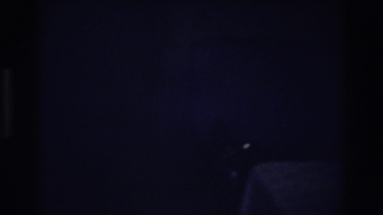 1968 Ocean City home-movie frame showing a man in glasses partly visible in a dark interior.